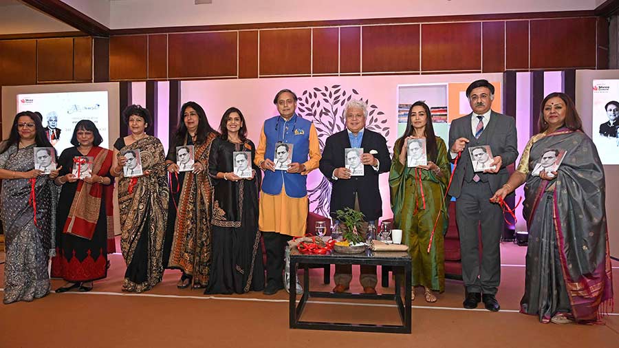 Tharoor, flanked by guests, poses with the newly launched book