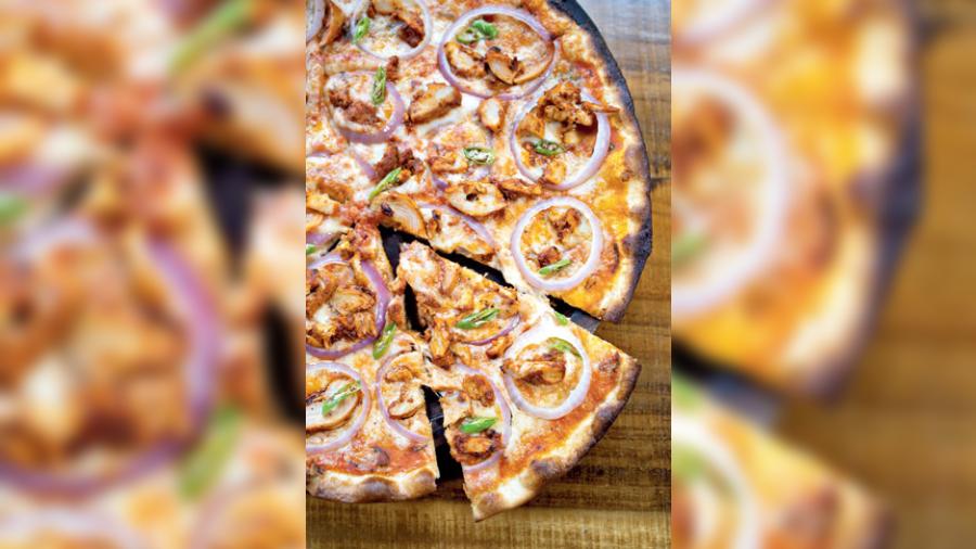 Chicken Tikka Pizza: Thin-crust pizza topped with green chilli and red onion rings. This one is for those that love their pizza with a desi twist.