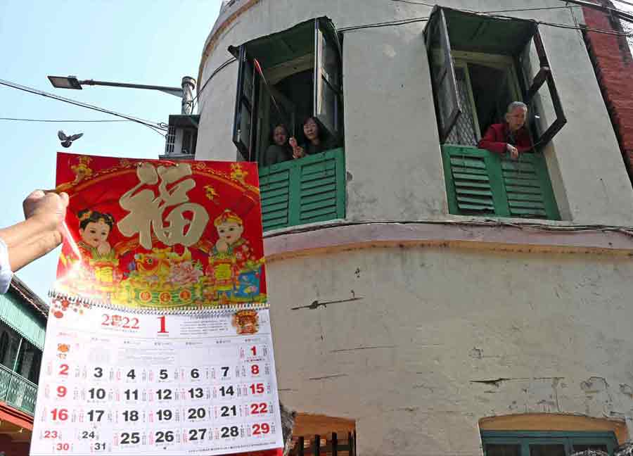 A reveller holds up a Chinese calendar. The New Year festival starts a couple of days before the New Year and continues for two weeks