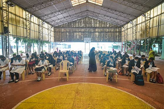 A basketball court has been converted into a classroom. Several schools are conducting offline lessons in halls and open-air spaces on the campus.