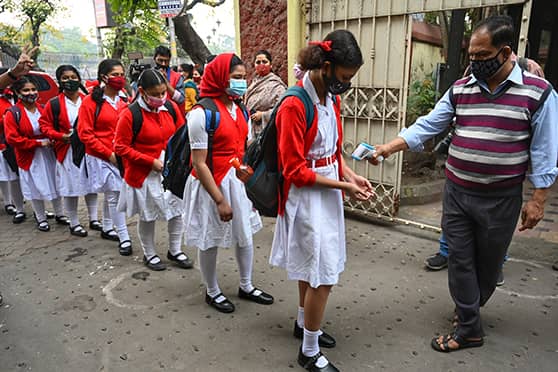 Girls line up for a mandatory temperature check at the Bethune Collegiate School gates.   