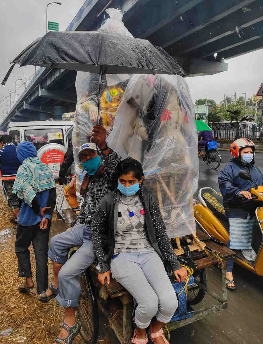 Devotees transport a Saraswati idol on a van-rickshaw on VIP Road on a rainy Friday morning