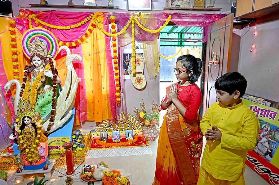 Two young devotees offer puja to goddess Saraswati at Nrityangayan Dance School at Baguiati in northeast Kolkata.  