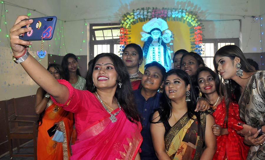 Students of Maharani Kasiswari College near Shyambazar in north Kolkata flaunt traditional attire and strike a pose in front of a Saraswati idol.  