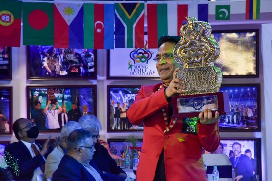 Suborno Bose lifts the Young Chef Olympiad 2022 Gold Winner trophy before declaring the winner. 