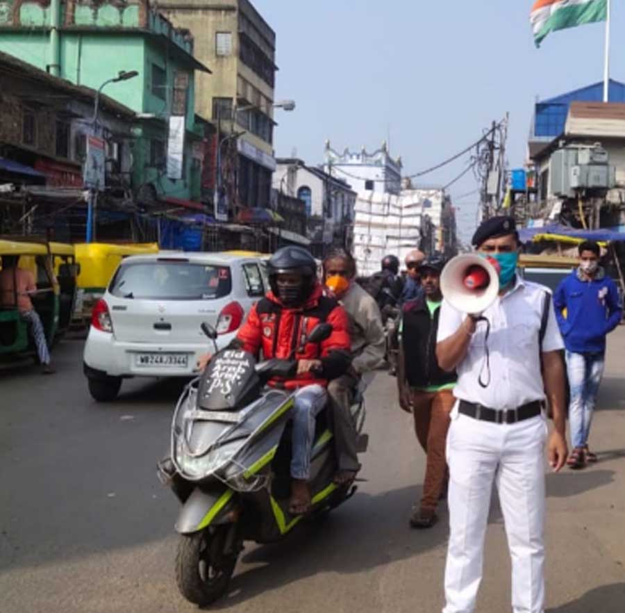 A policeman speaks through a loudspeaker at an awareness campaign on Covid-19 in Kolkata on Tuesday