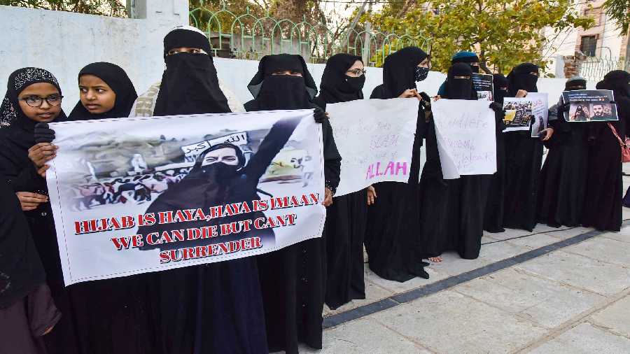 Muslim women holding placards participate at a mass prayer congregation, in solidarity with Muslim girl students of Karnataka. 