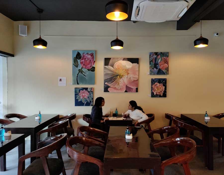 The cafe is spread over 2,000 square feet and seats 60 people. The wooden furniture is cosy and sleek. The series of floral paintings on the wall in hues of pink and purple, adds a pop of colour and makes for eye-catching decor