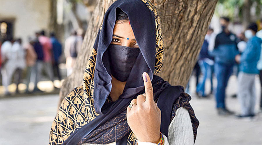 A woman shows her ink marked finger after casting her vote, during the first phase of UP Assembly polls, in Dadri, Thursday, Feb. 10, 2022.