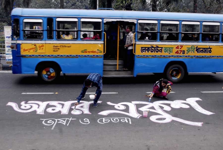Artists paint a message remembering the language martyrs in front of the Academy of Fine Arts on Sunday, the eve of International Mother Language Day