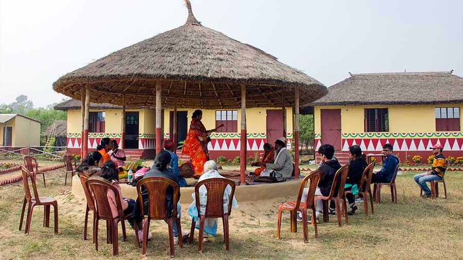 The open compound has a central thatched-roof podium for daily performances