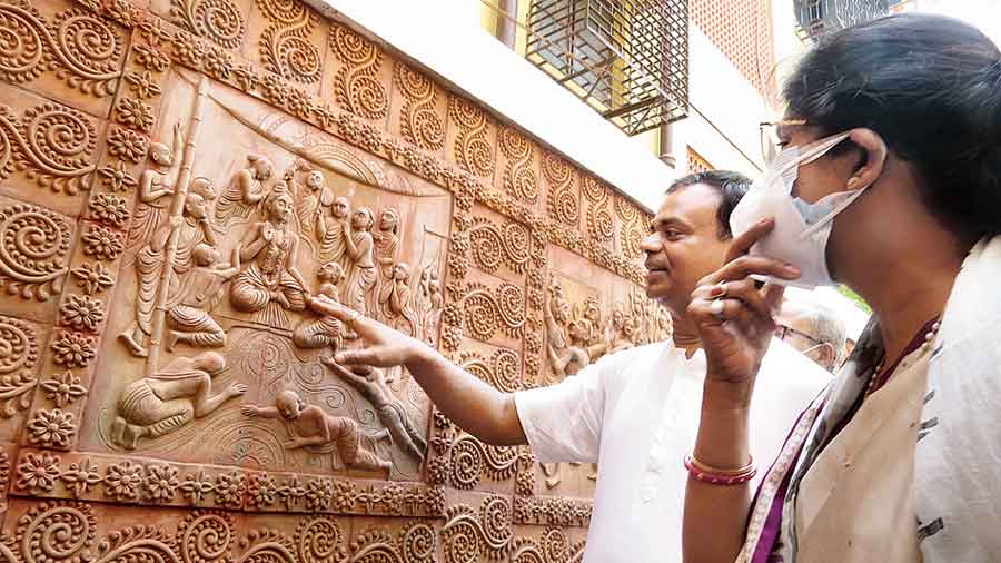 Radharaman Das of Iskcon shows etchings of Sri Chaitanya’s life in terracotta relief work to minister Sashi Panja on Monday.