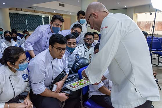 The London-based Sicilian chef explains to students of IIHM how marination in lemon juice can cook raw fish. The dish was made with thin slices of bhetki.