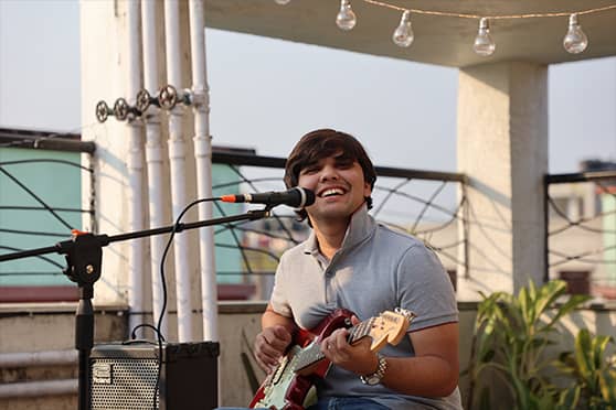 Young musician Aamir Rizvi smiles at the swaying crowd, as he performs an original song on his first date.