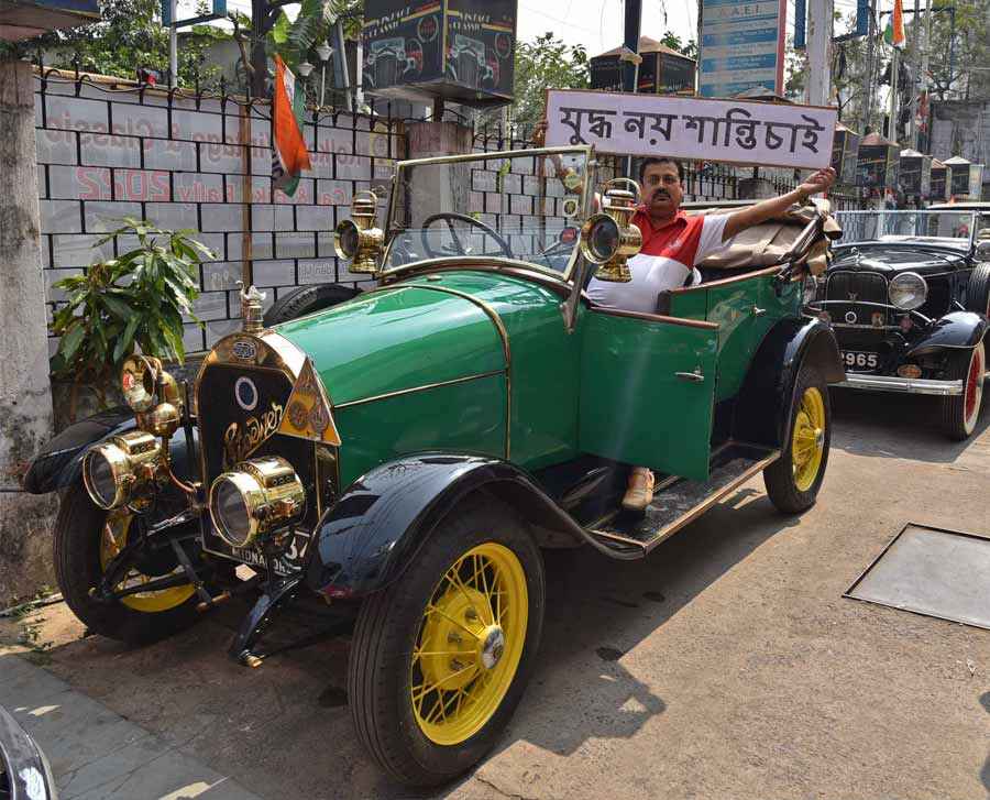ON ROAD TO PEACE: A man sitting in a 1913 Gebruder Stoewer holds an anti-war message during the selection round for a vintage car rally in Kolkata on Saturday, February 26. The vintage and classic car rally would be flagged off from Calcutta Club near Rabindra Sadan and end at Indian Life Saving Society on Southern Avenue on Sunday