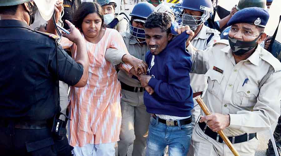 DYFI state secretary Minakshi Mukherjee (left) being taken away by the police from the protest rally at Panchla in Howrah on Saturday.