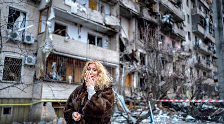 Natali Sevriukova reacts next to her house following a rocket attack on the city of Kyiv, Ukraine.