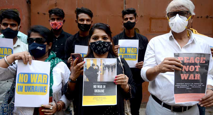 People hold posters with anti-war messages at Gorky Sadan on Sunday