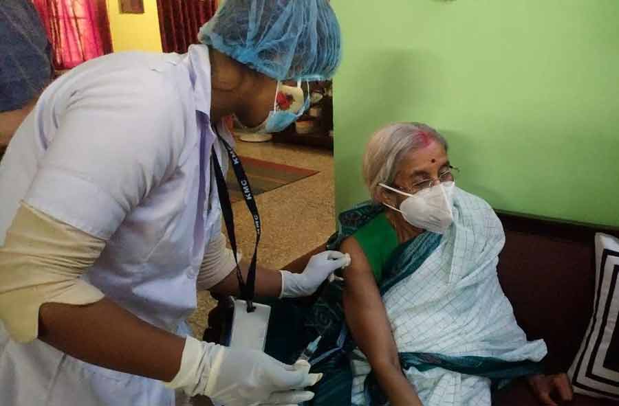 A health worker vaccinates an elderly woman at her home on Monday