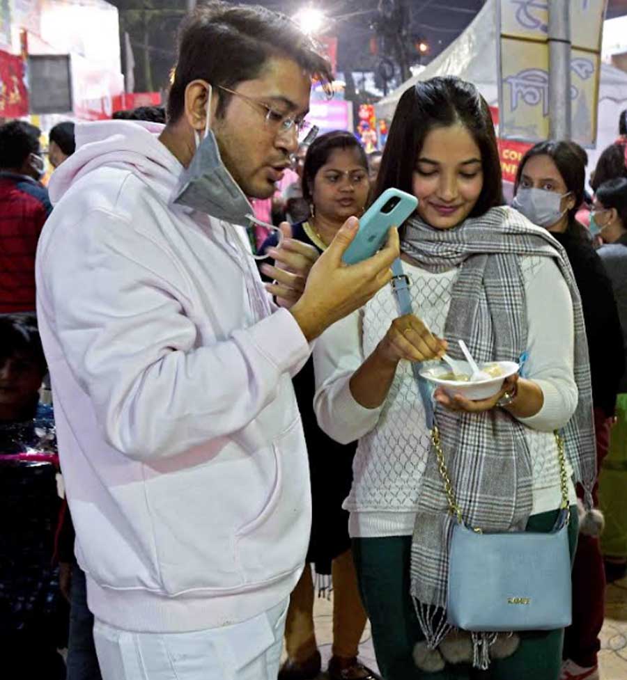 WINTER INDULGENCE: Dressed in smart winter casuals, a sweetmeat connoisseur digs into a bowlful of ‘doodh pitha’ at the Sreebhumi Poush Parbon Utsab 2021 in Lake Town in northeast Kolkata on December 28, Tuesday. The fair will continue till Sunday, January 2. 