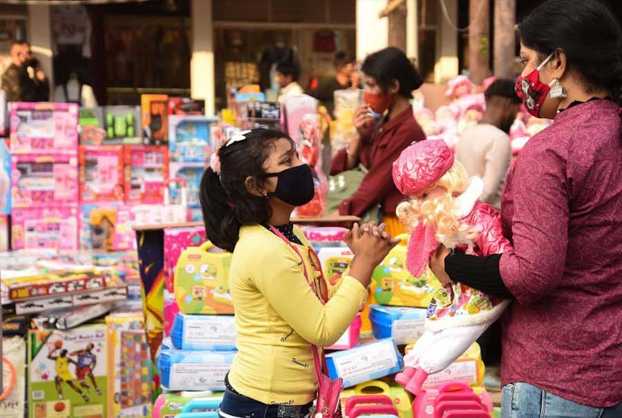 ‘MOTHER’ SANTA: Christmas may have come and gone but this child pleads with her mother to buy her a toy from a streetside vendor near New Market in central Kolkata on Thursday, December 30. 