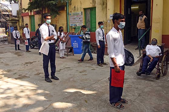 Students practise social distancing as they wait outside Town School in Kolkata. Vaccination camps have been set up at government, semi-government and private schools in West Bengal. Teenagers can also receive their shots at 338 hospitals and medical colleges across the state and 37 health clinics run by the Kolkata Municipal Corporation (KMC). 