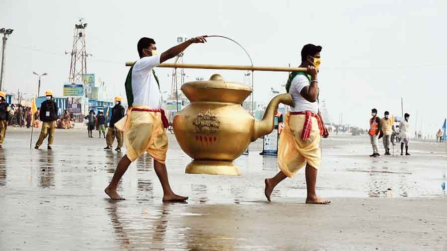 Devotees on Tuesday carry one of the giant kamandalus (water pots) containing the holy water of the Ganga for journey across 23 Bengal districts.
