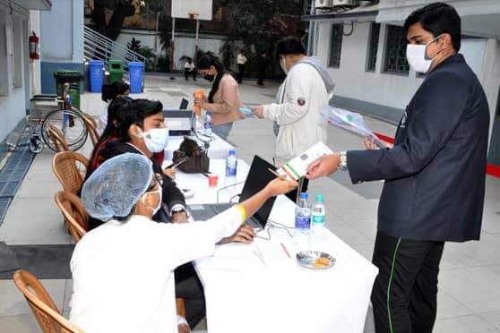 A student of Birla High School gets his Aadhaar Card checked before vaccination. 