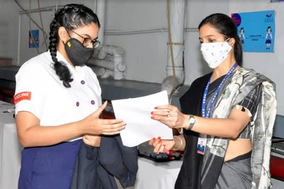 A student receives the vaccination certificate. After vaccination, students were under medical observation for 30 minutes. 