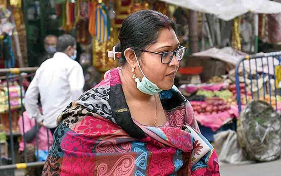 A woman going around stalls in a market in Bhowanipore in south Kolkata had her mask resting on the chin.
