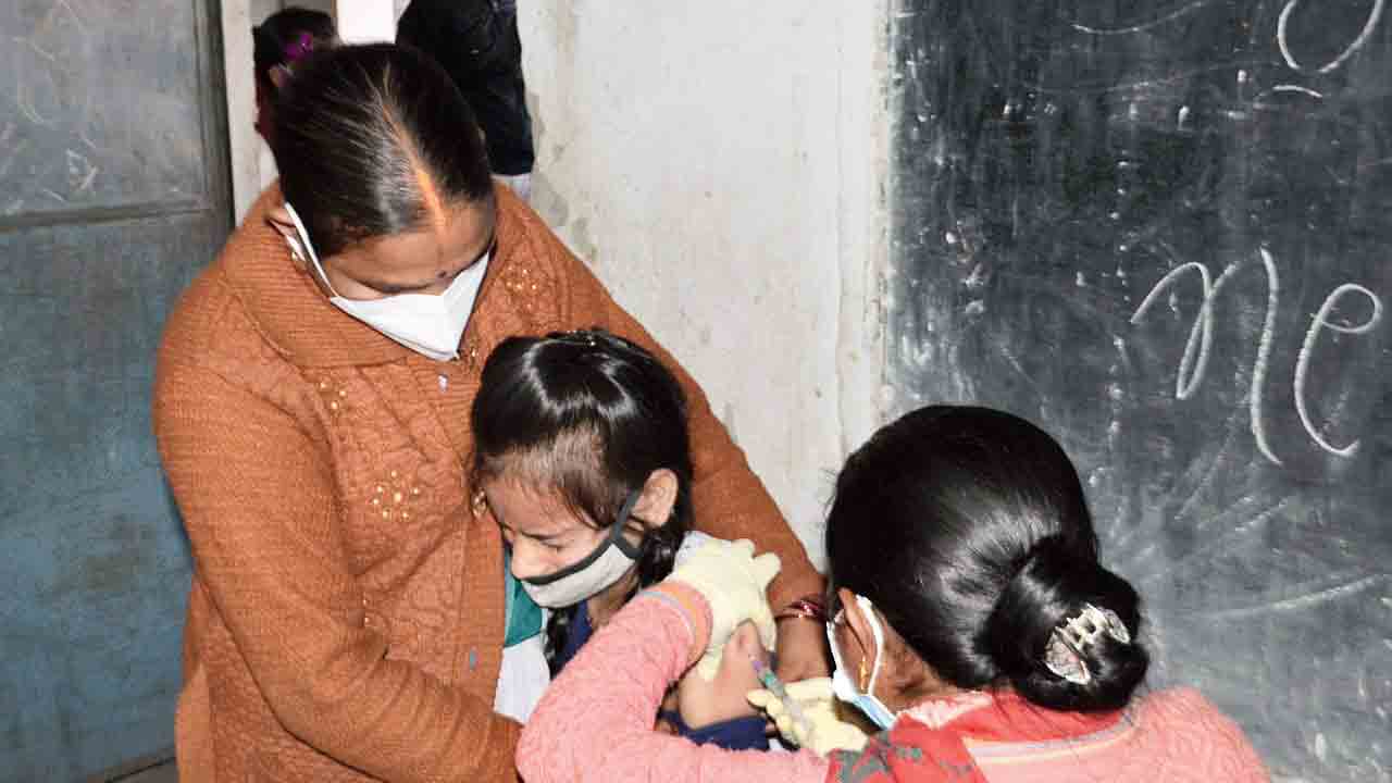 A teenager is being administered the first dose of a Covid vaccine in Dhanbad