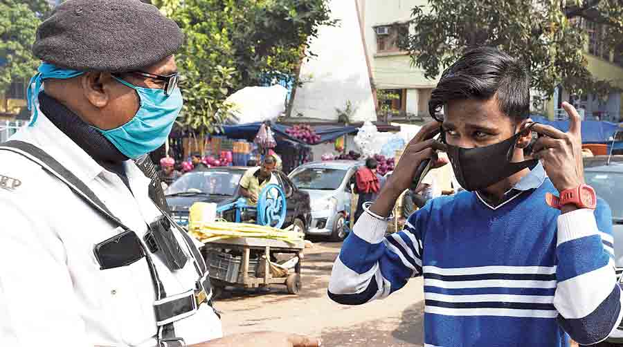 A policeman makes a pedestrian wear a mask on Brabourne Road on Tuesday.