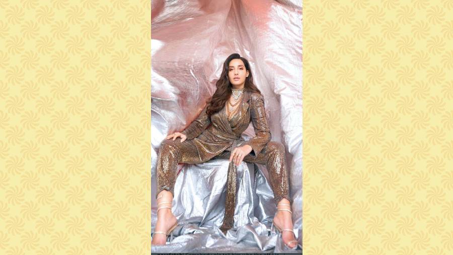 Nothing captures the essence of winter merry mood in fashion more than bling. Sequins, metallic outfits, accessories or make-up — there can be various ways of channelling the trend. One usually thinks of a sequinned dress to glam up for a party or any kind of celebration and we absolutely loved how Bolly hottie Nora Fatehi rocks a golden pantsuit with a mix-and-match of Indian jewellery and western accessories. A smart choice especially if you have an outdoor event to attend. The pantsuit will keep you covered and the bling will add glamour.