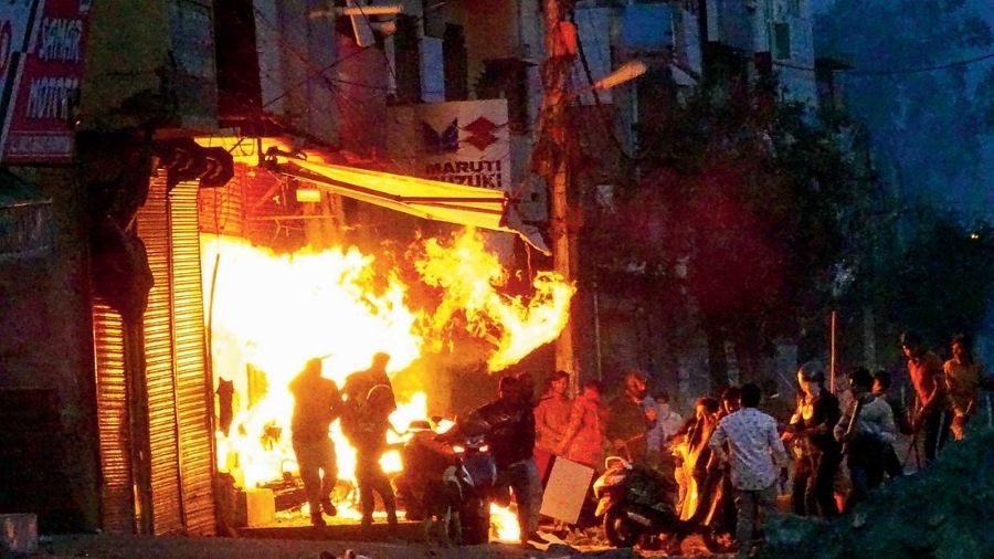 Rioters set ablaze a shop in northeast Delhi.