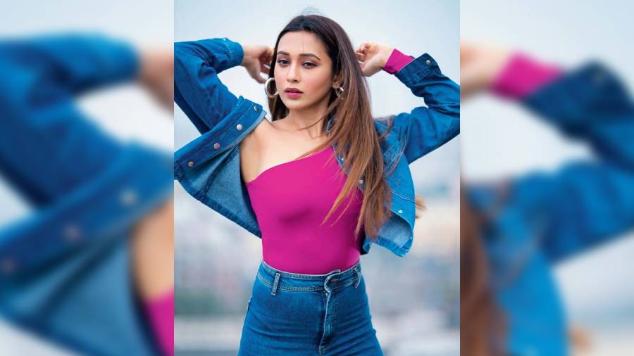 With or without a jacket —  Mimi Chakraborty couldn’t decide which is better! We say with the jacket she looked cooler! We are loving the denim-on-denim look with a spurt of fuchsia with this one-shouldered top. The hoops, eyeliner and straight hair rounded off her look.