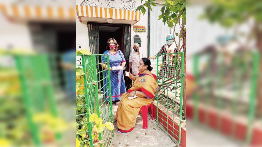 Ward 29 candidate Krishna Chakraborty takes a tea break in an AK Block resident’s driveway after being invited in.