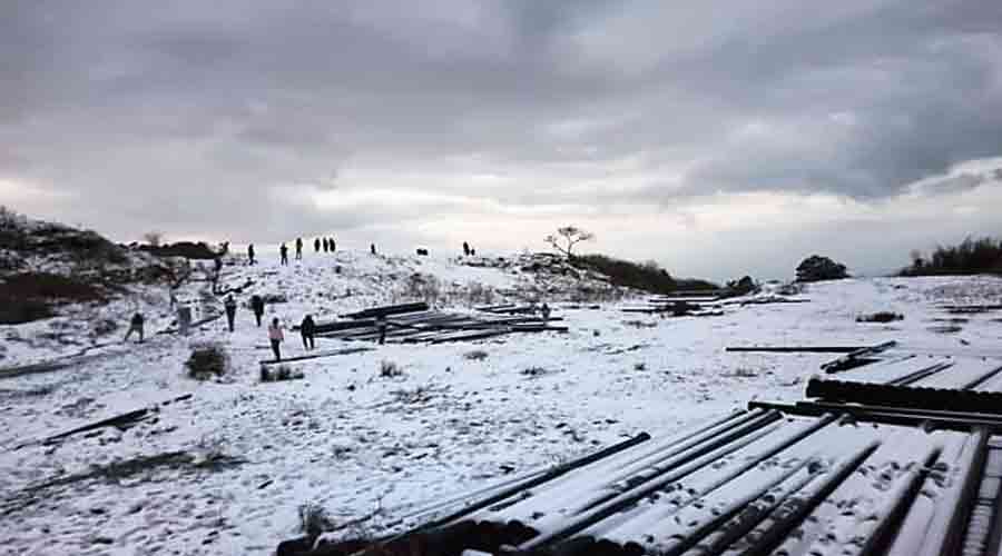 Pictures show Tiger Hill, located 8,000ft above the sea level and near the Darjeeling town, wrapped in the snow on Friday.