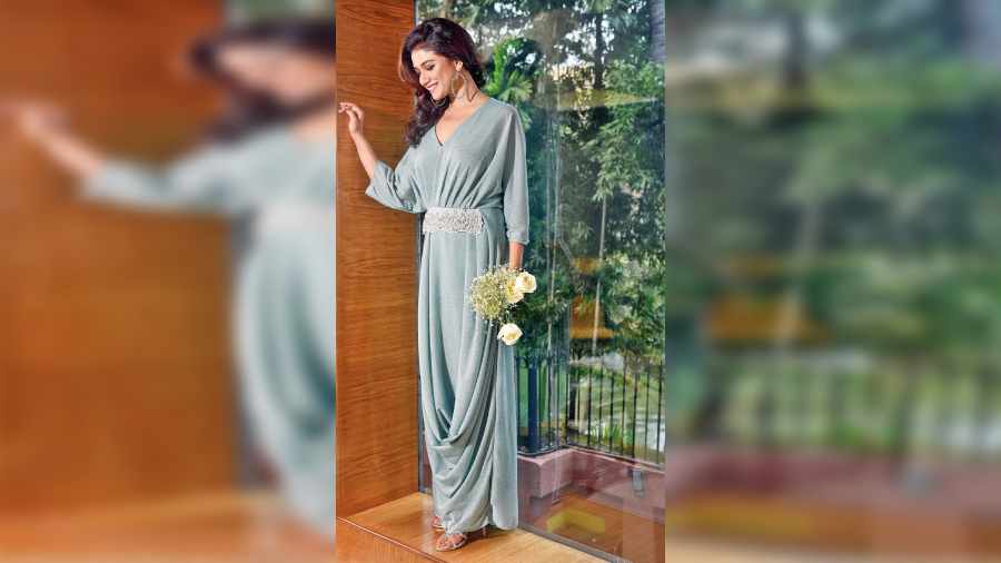 Sauraseni channelled elegance in this soothing pastel green draped outfit. The trendy shimmer touch makes it apt as a festive or wedding occasion-wear during spring. The pearl-drop accessorised detailing at the front and cascading drapes on one side give an easy-breezy touch to the outfit.