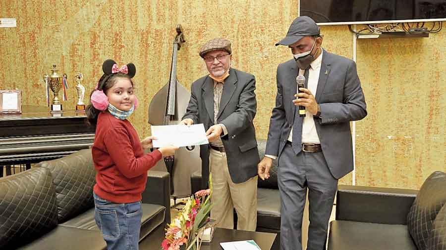 Anup Matilal hands the winner’s certificate to Samriddhi Majumdar of AB Block, who won both the drawing and the recitation contests
