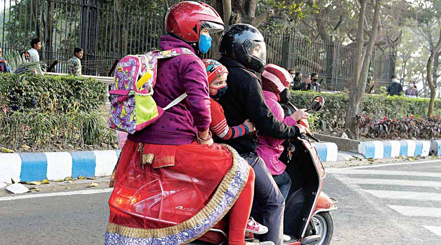 A family wrapped in woollens on a two-wheeler on Mayo Road on Friday afternoon. 