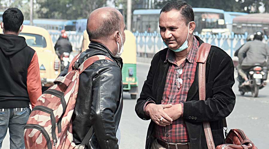 Two men in Tollygunge, both without a mask, were talking in close quarters. “We are wearing the mask (on the chin) and we are talking… we will board a car,” said one of them (the one with a side bag)