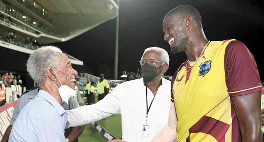 Jason Holder (right) shakes hands with Garfield Sobers (left) after winning the 5th T20I against England at Kensington Oval on Sunday.