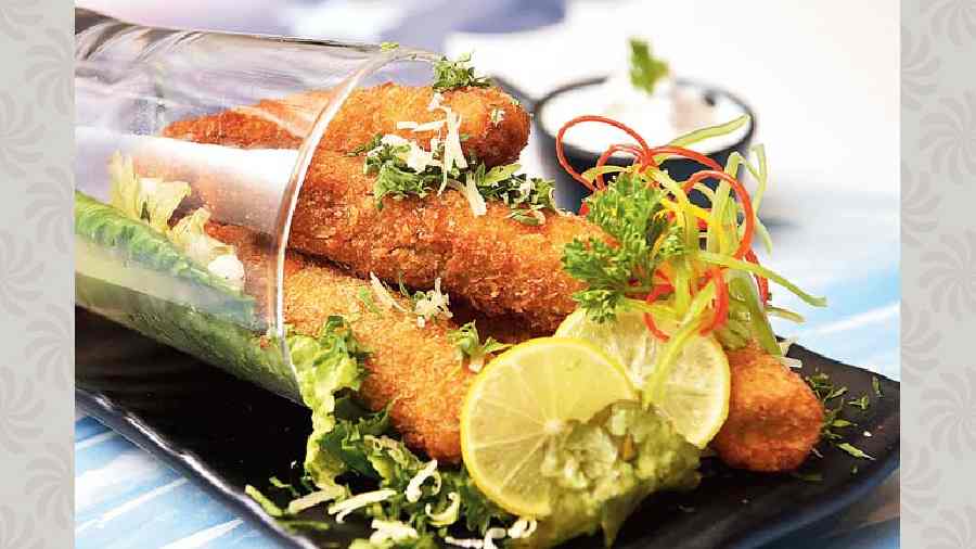 Fingered Fish: A quintessential finger food item, this one has a special whiff of mustard dressing within its coating that elevates the flavours a notch higher. It is served with home-made tartare sauce. @Rs 345-plus