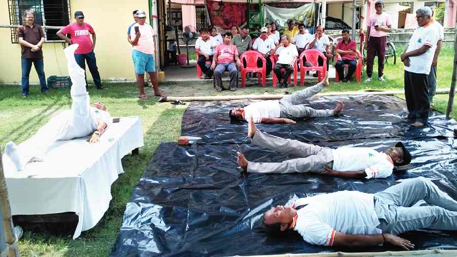 Men do yoga outdoors in CB Block