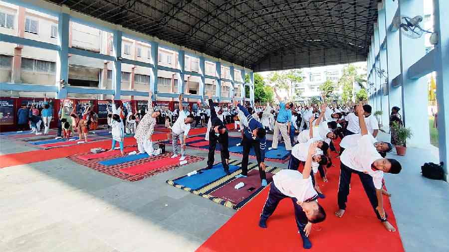 Students, teachers and guardians together perform asanas