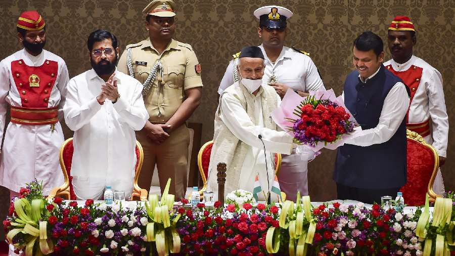 Newly elected Maharashtra Deputy Chief Minister Devendra Fadnavis being presented a bouquet by Governor Bhagat Singh Koshyari during his oath-taking ceremony, at Raj Bhavan in Mumbai