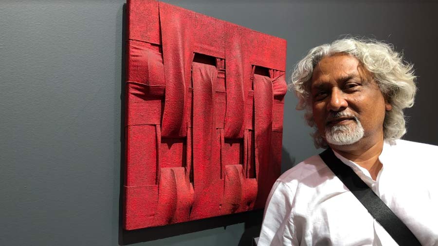 Kunal Basu poses with an artwork at Art Basel, Basel, Switzerland