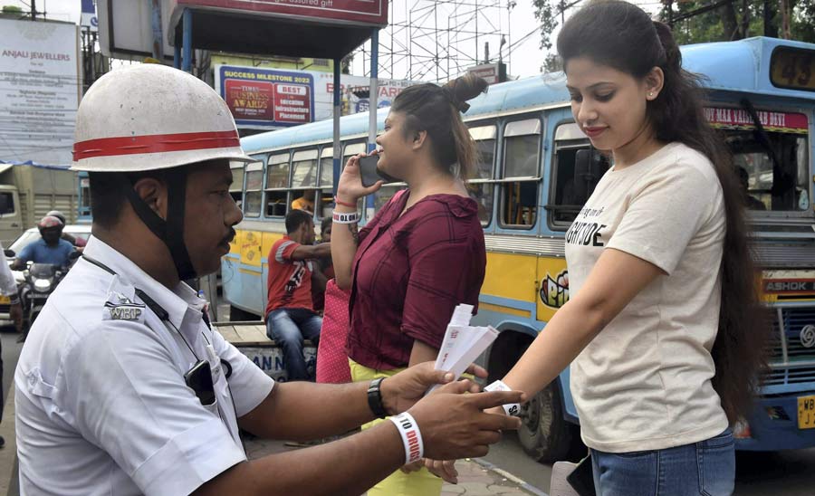 A policeman ties a wristband on a woman as part of an awareness campaign on International Day Against Drug Abuse and Illicit Trafficking on Sunday, June 26.