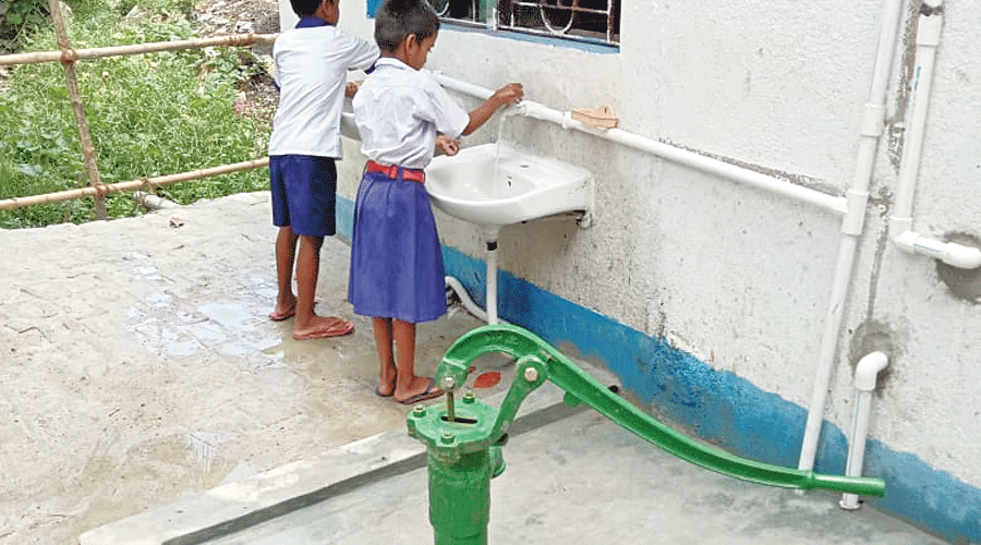 Kids use the wash basin installed at the school.