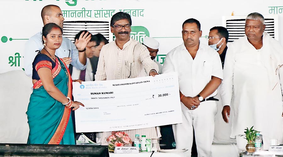 Hemant Soren hands over a cheque to a beneficiary during the programme in Dhanbad on Monday. 